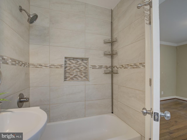 bathroom featuring crown molding, tiled shower / bath, wood-type flooring, and sink