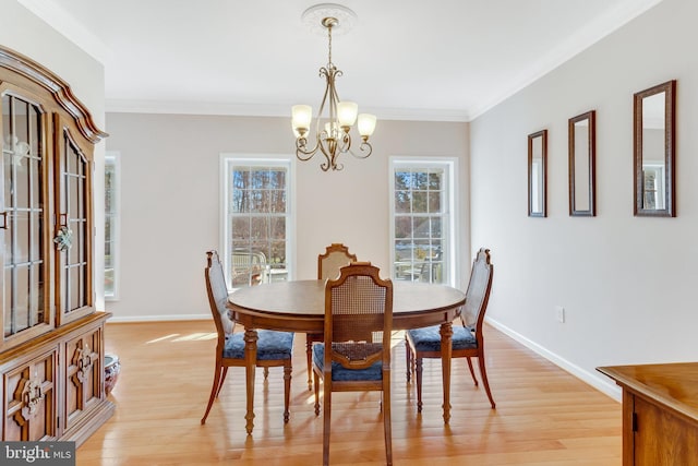 dining area featuring ornamental molding, a chandelier, and light hardwood / wood-style flooring