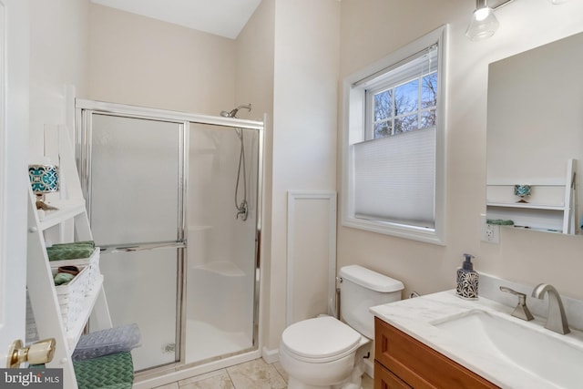 bathroom featuring tile patterned flooring, vanity, an enclosed shower, and toilet