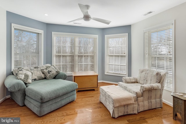 sitting room with ceiling fan and light wood-type flooring