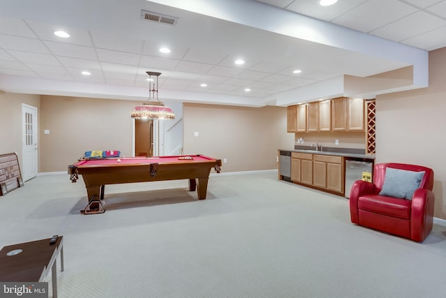 recreation room featuring a paneled ceiling, light carpet, and indoor wet bar