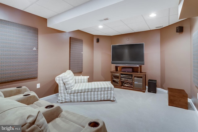 living room with a drop ceiling and carpet