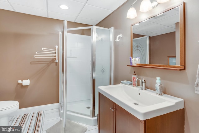 bathroom with a paneled ceiling, vanity, an enclosed shower, tile patterned floors, and toilet