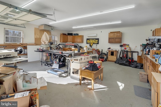 garage featuring a workshop area and a wall mounted AC