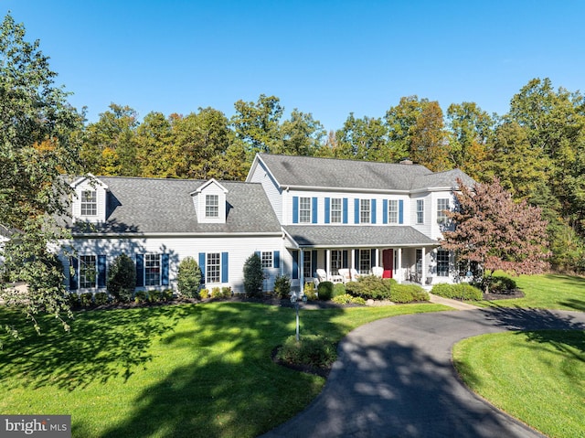 colonial home featuring a front yard and covered porch