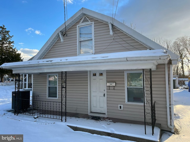 bungalow-style home with covered porch and central AC unit