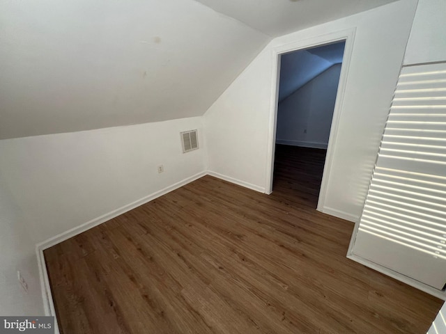 additional living space with lofted ceiling and dark wood-type flooring