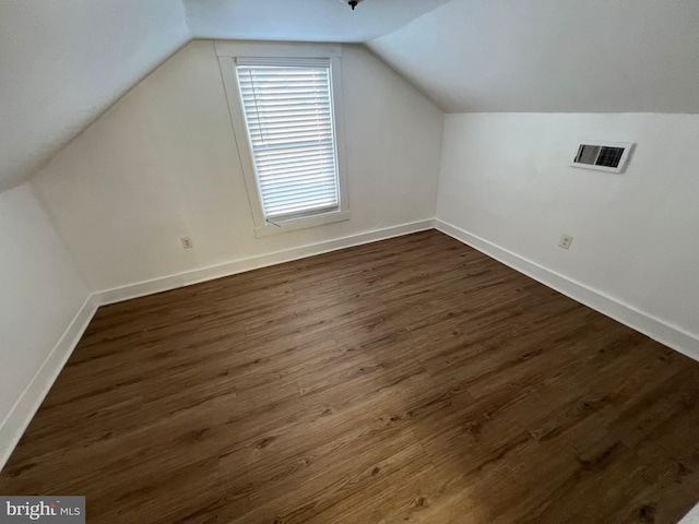 additional living space featuring dark hardwood / wood-style floors and lofted ceiling