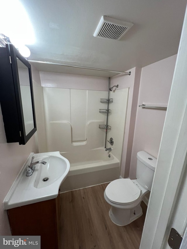 full bathroom with vanity, toilet, wood-type flooring, and shower / washtub combination