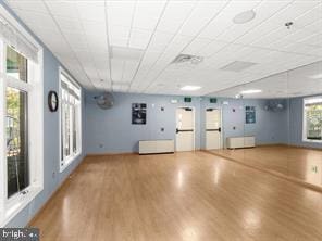 interior space with wood-type flooring and a drop ceiling