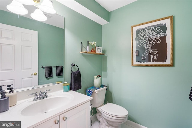 bathroom featuring toilet, vanity, and a notable chandelier