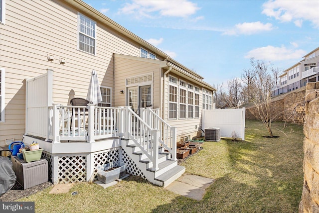 back of property with central air condition unit, a deck, and a lawn