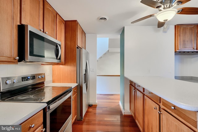 kitchen featuring ceiling fan, dark wood-type flooring, backsplash, and stainless steel appliances