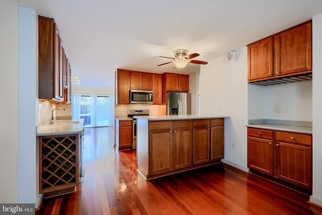 kitchen featuring ceiling fan, sink, appliances with stainless steel finishes, and dark hardwood / wood-style flooring