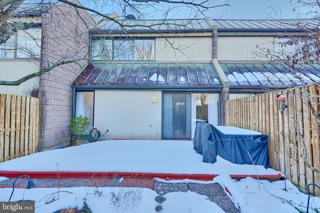 view of snow covered rear of property