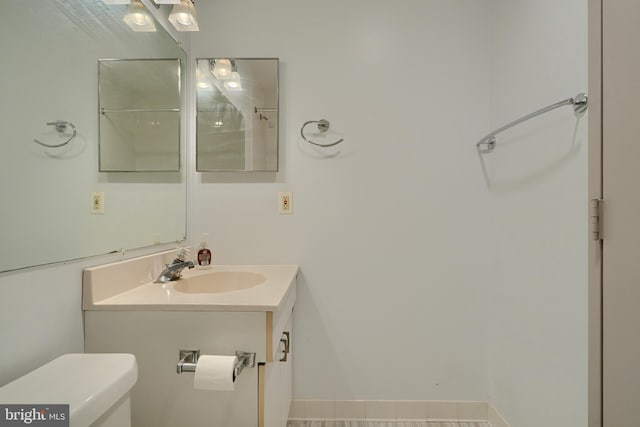 bathroom with toilet, vanity, and tile patterned floors