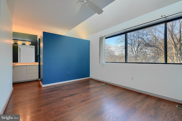 unfurnished bedroom with ceiling fan and dark wood-type flooring