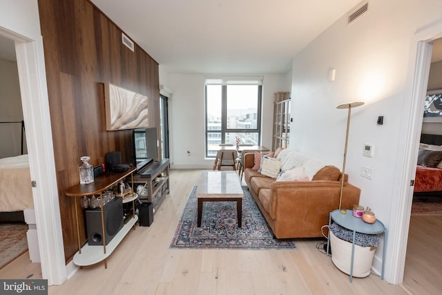 living room featuring expansive windows and light hardwood / wood-style flooring