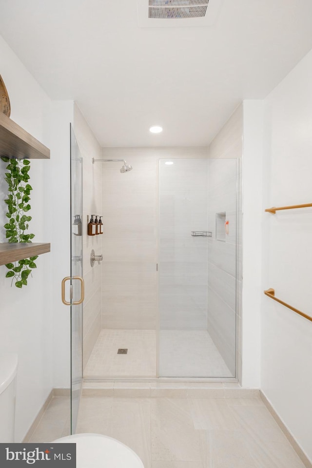 bathroom featuring a shower with door and tile patterned flooring