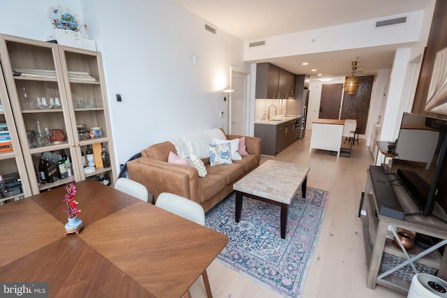 living room featuring sink and light hardwood / wood-style floors