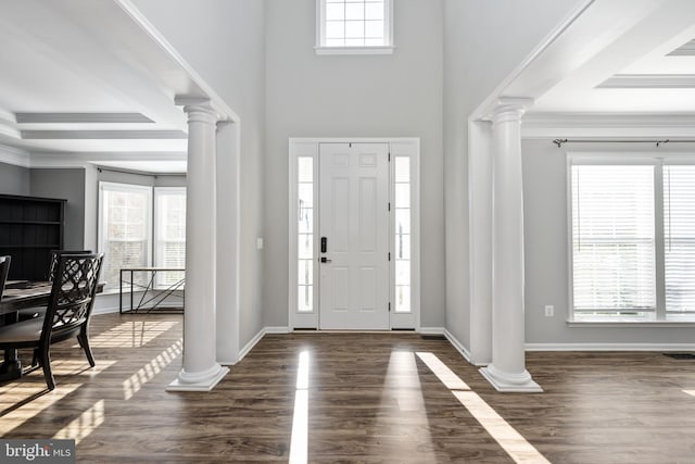 entrance foyer with dark wood-type flooring, crown molding, and decorative columns