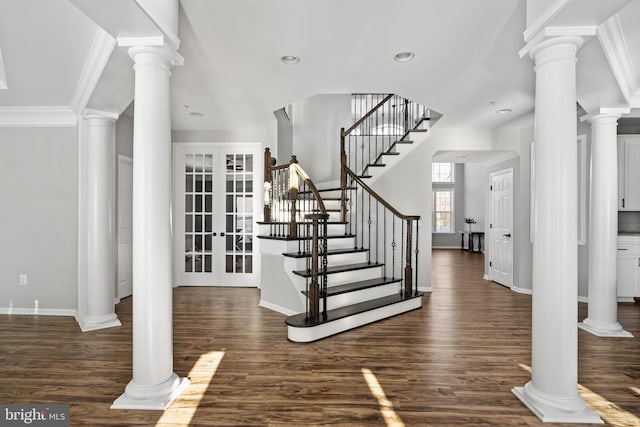 foyer with french doors, dark wood-type flooring, and crown molding