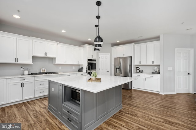 kitchen featuring white cabinetry, a center island with sink, appliances with stainless steel finishes, dark hardwood / wood-style flooring, and light stone counters