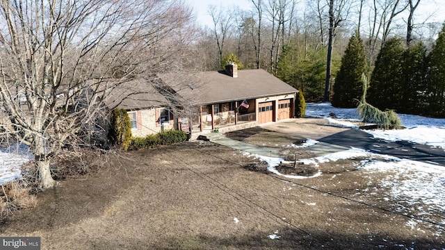 view of front of property featuring a garage, driveway, and a chimney