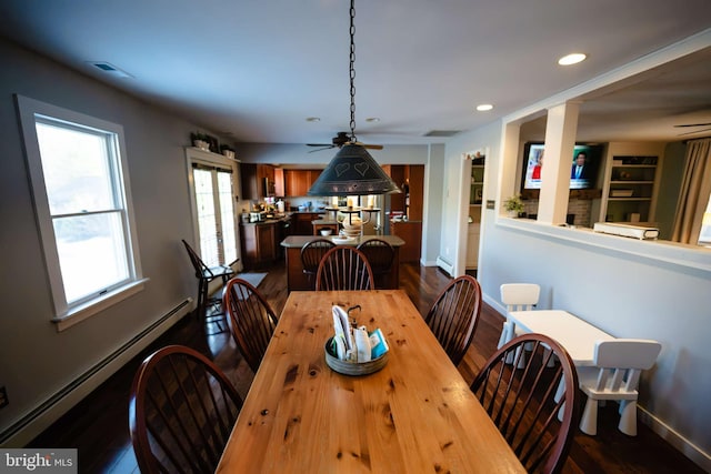 dining space featuring wood-type flooring, built in shelves, and a baseboard heating unit