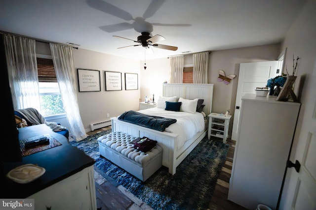 bedroom with ceiling fan, dark hardwood / wood-style flooring, and a baseboard heating unit