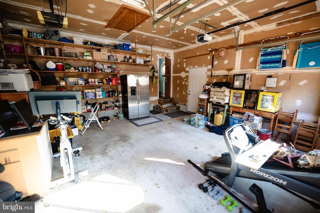 garage with stainless steel fridge and a garage door opener