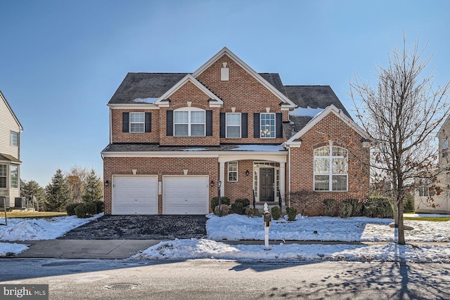 view of front property with a garage and central AC