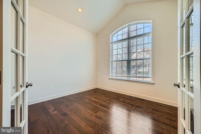 unfurnished room featuring lofted ceiling, french doors, and dark hardwood / wood-style flooring