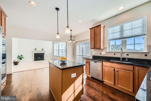 kitchen with appliances with stainless steel finishes, dark hardwood / wood-style floors, hanging light fixtures, a chandelier, and sink