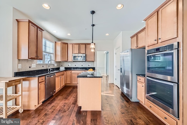 kitchen with pendant lighting, a center island, stainless steel appliances, sink, and dark hardwood / wood-style floors