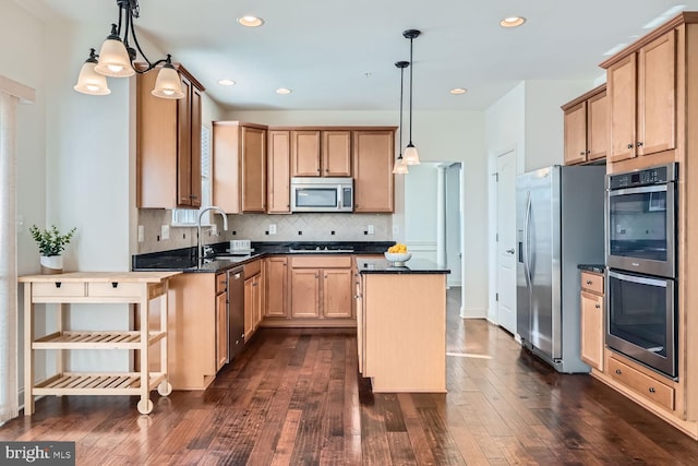 kitchen with stainless steel appliances, dark hardwood / wood-style floors, a center island, decorative light fixtures, and sink