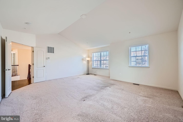 unfurnished room featuring lofted ceiling and carpet flooring