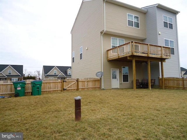 back of house featuring a lawn and a wooden deck