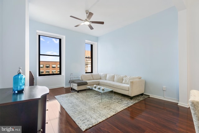 living room featuring ceiling fan and dark wood-type flooring