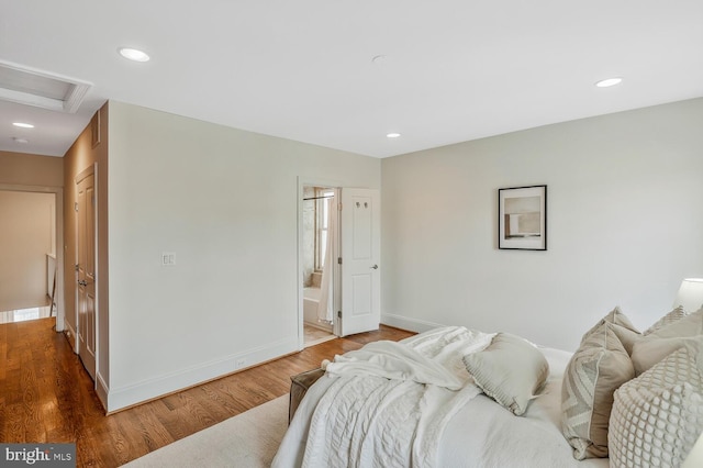 bedroom with hardwood / wood-style flooring and ensuite bathroom