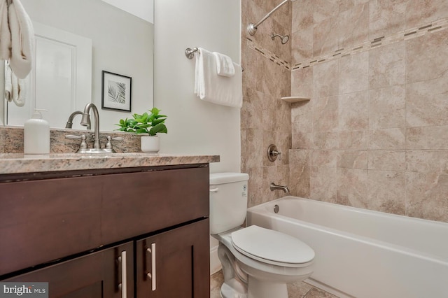 full bathroom featuring tiled shower / bath, vanity, and toilet