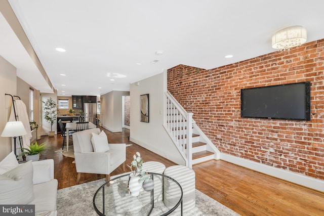 unfurnished living room featuring brick wall and wood-type flooring