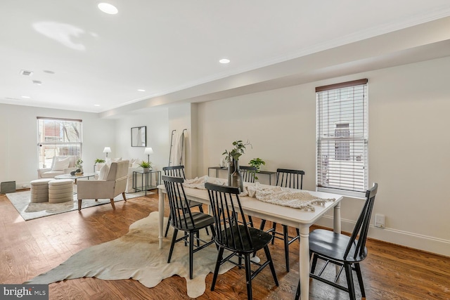 dining space with hardwood / wood-style floors and ornamental molding