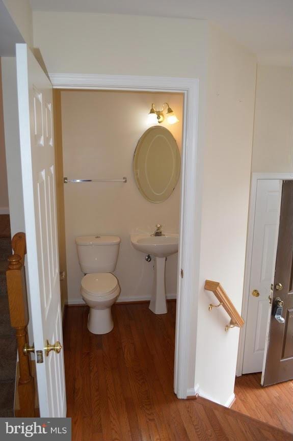 bathroom featuring wood-type flooring and toilet