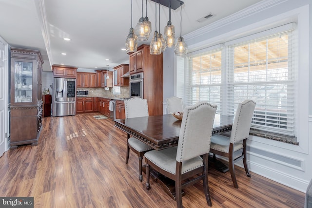 dining space featuring dark wood-type flooring and ornamental molding