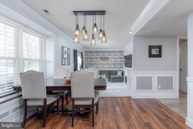 dining room with crown molding, wood-type flooring, and a notable chandelier