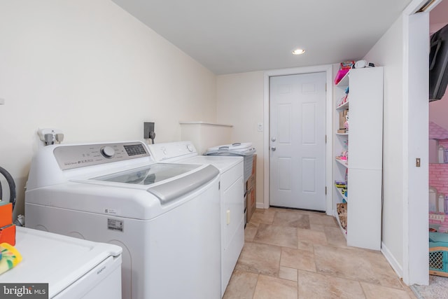 clothes washing area with washing machine and dryer