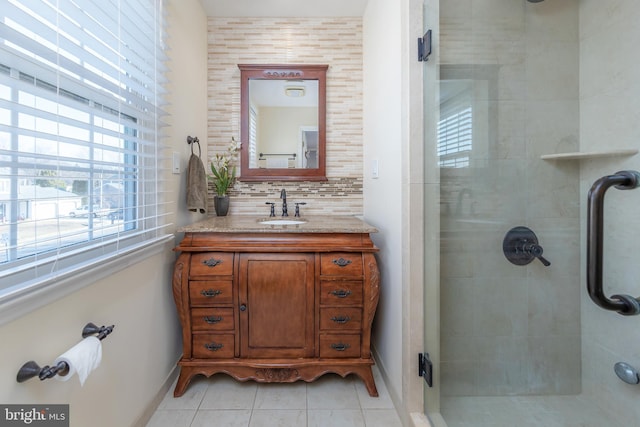 bathroom with tile patterned flooring, vanity, tasteful backsplash, and walk in shower