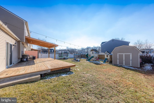 view of yard with a shed, a playground, and a wooden deck