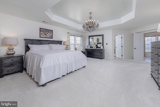 carpeted bedroom with a notable chandelier, a tray ceiling, and crown molding